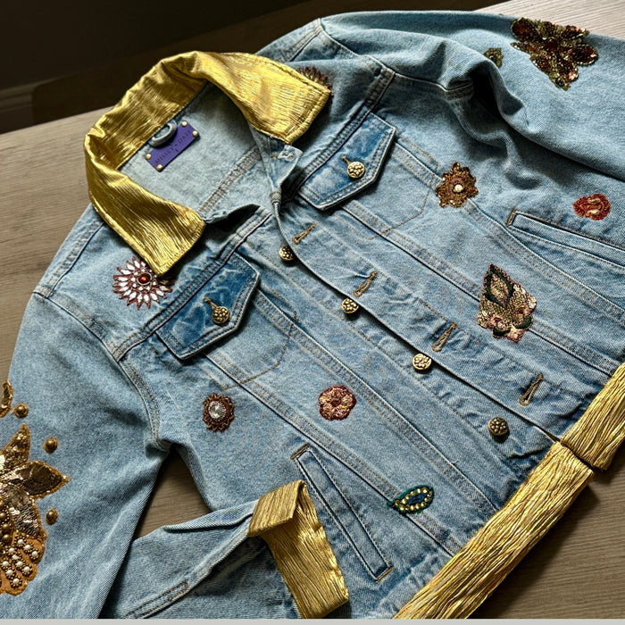 front view of blue denim jacket with gold trim and floral embellishments