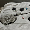 White denim jacket with decorative patches with crystals and gemstones 