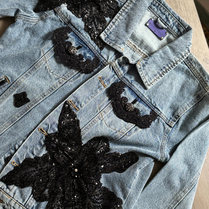 close-up of black lace floral appliqué and beadwork on denim jacket