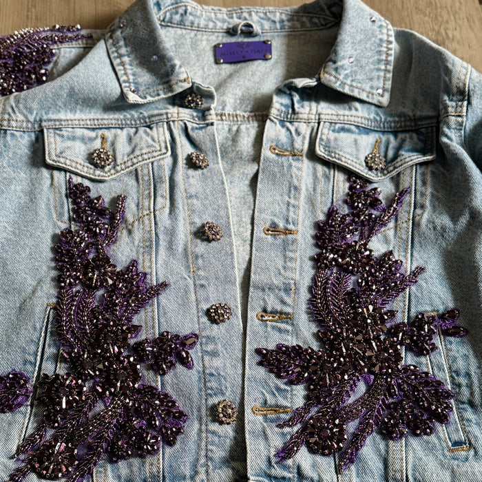 close-up of handcrafted purple floral appliqué beaded embellishments on denim